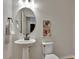Small half bathroom with pedestal sink, oval mirror, and framed art at 8710 Hinsdale Heights Dr, Polk City, FL 33868