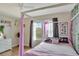 Charming bedroom with canopy bed, large window, and decorative wall accents at 8710 Hinsdale Heights Dr, Polk City, FL 33868