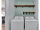 Bright laundry room with washer, dryer, and custom wood shelves at 8710 Hinsdale Heights Dr, Polk City, FL 33868