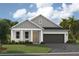 One-story home with gray siding, a two-car garage, and a landscaped lawn at 6201 Sw 97Th St, Ocala, FL 34476
