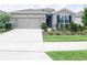 Single-story house with a two-car garage and landscaped front yard at 5450 Sunshine Dr, Wildwood, FL 34785