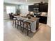 Modern kitchen with island, dark cabinets, and granite countertops at 5450 Sunshine Dr, Wildwood, FL 34785