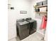Well-appointed laundry room with washer, dryer, and storage shelves at 5450 Sunshine Dr, Wildwood, FL 34785