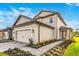 Two-story house with light beige siding, brown accents, and a paved walkway at 7748 Somersworth Dr, Kissimmee, FL 34747