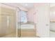 The bathroom showcases a soaking tub below a window, complemented by a glass-enclosed shower and white door at 4026 Navigator Way, Kissimmee, FL 34746