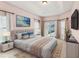 Staged Primary bedroom features en-suite bath, TV, and sliding glass doors to lanai at 4026 Navigator Way, Kissimmee, FL 34746