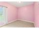 This bedroom features pink walls, tile flooring, and a window with curtains allowing natural light at 4026 Navigator Way, Kissimmee, FL 34746
