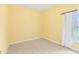 A sunny bedroom showcasing yellow walls, tile flooring, and a window with sheer white curtains at 4026 Navigator Way, Kissimmee, FL 34746