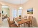Dining room with wood table and chairs, neutral walls, and view to front living area at 4026 Navigator Way, Kissimmee, FL 34746