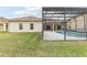 An enclosed pool area is surrounded by lush green grass in the backyard at 4026 Navigator Way, Kissimmee, FL 34746