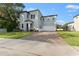 Two-story house with gray siding, brick driveway and landscaped lawn at 213 Aidans Ldg, Haines City, FL 33844