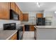 Kitchen with wood cabinets, black appliances, and tile flooring at 10555 Leader Ln, Orlando, FL 32825
