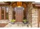 Elegant brown front door with a stone facade at 15241 Colley Dr, Tavares, FL 32778