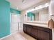 Bathroom with teal walls, double vanity, and walk-in shower at 2130 Sequoia Way, Davenport, FL 33896