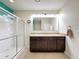 Bathroom with teal walls, double vanity, and walk-in shower at 2130 Sequoia Way, Davenport, FL 33896