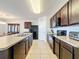 Spacious kitchen boasts ample counter space, dark wood cabinets, and stainless steel appliances at 2130 Sequoia Way, Davenport, FL 33896