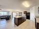 Open kitchen features an island, stainless steel appliances, and a view into the living room at 2130 Sequoia Way, Davenport, FL 33896