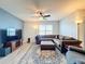 Comfortable living room featuring sectional sofa, large TV, and ceiling fan at 2130 Sequoia Way, Davenport, FL 33896