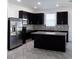 Modern kitchen with dark cabinetry, granite counters, and stainless steel appliances at 2180 Nighthawk Dr, Haines City, FL 33844