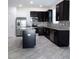 Modern kitchen with dark cabinetry, granite counters, and stainless steel appliances at 2180 Nighthawk Dr, Haines City, FL 33844