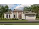 One-story home with a two-car garage, light beige exterior, and landscaping at 4807 Waltham Forest Dr, Davenport, FL 33837