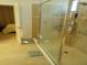 A modern glass shower, with a view into the connected bedroom, showcasing the home's luxurious design at 621 San Augusto Dr, Poinciana, FL 34759