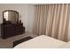 Bedroom with a large mirror, dresser and an ottoman at the foot of the bed, featuring neutral toned decor at 621 San Augusto Dr, Poinciana, FL 34759