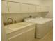 Bright laundry room with washer, dryer, sink and storage cabinets at 621 San Augusto Dr, Poinciana, FL 34759