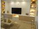Modern living room showcasing built-in shelving with decor, a large television, and tile flooring at 621 San Augusto Dr, Poinciana, FL 34759