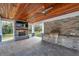 Outdoor kitchen with fireplace, built-in grill, and wood-beamed ceiling at 2750 W Pipkin Rd, Lakeland, FL 33811