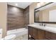 Modern bathroom with wood vanity, tile shower, and white tub at 1528 Walker Rd, Lakeland, FL 33810