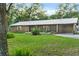 Brick ranch home with metal roof, landscaping, and a spacious yard at 1528 Walker Rd, Lakeland, FL 33810