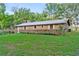 Brick ranch house with metal roof, landscaping, and a spacious yard at 1528 Walker Rd, Lakeland, FL 33810