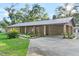 Brick ranch house with carport, mature landscaping, and a spacious yard at 1528 Walker Rd, Lakeland, FL 33810