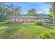 Brick ranch home with metal roof, lush landscaping, and a detached garage at 1528 Walker Rd, Lakeland, FL 33810
