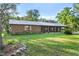 Brick ranch house with metal roof, landscaped yard, and screened porch at 1528 Walker Rd, Lakeland, FL 33810