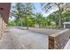 Large concrete patio with brick wall and lush landscaping at 1528 Walker Rd, Lakeland, FL 33810