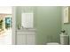 Small bathroom with green walls, white vanity, and toilet at 2653 Skyline Loop, Kissimmee, FL 34758