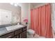 Clean bathroom with granite countertop, coral shower curtain, and updated vanity at 644 Hudson Valley Dr, Kissimmee, FL 34759