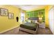 Bedroom with a green bedspread, tennis-themed decor, and yellow walls at 274 Puma Loop, Groveland, FL 34736