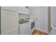 Bright laundry room with white washer, dryer, and built-in cabinets at 4545 Mandolin Blvd, Winter Haven, FL 33884