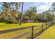 House with a large front yard, wooden fence, and mature trees at 6104 Irby W Ln, Lakeland, FL 33811