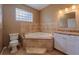 Primary bathroom showcasing a tub, glass block window, and vanity with granite counter at 1507 Hontoon Rd, Deland, FL 32720