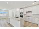 Bright open kitchen featuring white cabinetry, stainless steel appliances, and a center island at 1254 Lakeridge Way, Lake Alfred, FL 33850