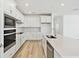 Bright open kitchen featuring white cabinetry, stainless steel appliances, and center island at 1254 Lakeridge Way, Lake Alfred, FL 33850