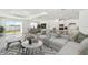 Bright, open-concept living room featuring white sectional sofa, dining area, and modern kitchen with stainless steel appliances at 1254 Lakeridge Way, Lake Alfred, FL 33850