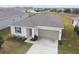 Single-story house featuring solar panels, a garage, and a well-manicured lawn at 1734 Hill Top Dr, Dundee, FL 33838