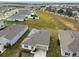 Aerial view showcasing a single-story house, solar panels, and a neighborhood at 1734 Hill Top Dr, Dundee, FL 33838