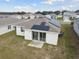 Aerial view of a house with solar panels and a backyard at 1734 Hill Top Dr, Dundee, FL 33838