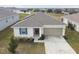 Single-story house with solar panels, a garage, and landscaping at 1734 Hill Top Dr, Dundee, FL 33838
